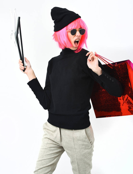 fashionable sexy girl in pink wig holding package with hangers - Valokuva, kuva