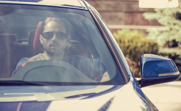 Handsome serious man driving a car - 写真・画像
