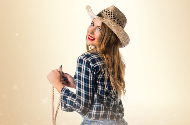 Sexy blonde woman cowgirl on ocher background - Photo, Image