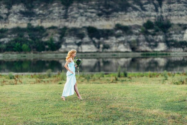 Mavi elbiseli, photosession bahar niteliğine hafif kıvırcık kız - Fotoğraf, Görsel