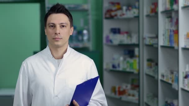 Mosolygó férfi gyógyszerész gyógyszertár fehér kabát - Felvétel, videó
