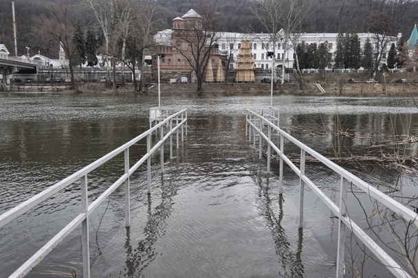 A ponte no rio inundada com água derramada
 - Foto, Imagem
