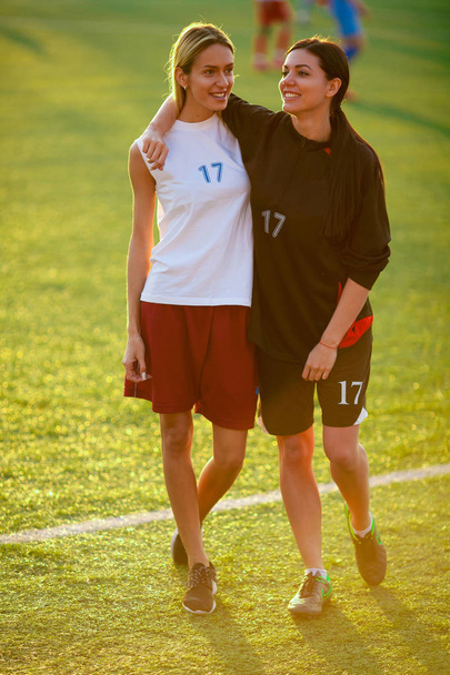 Két átfogó lányok egy Futballmez, állva a foci - Fotó, kép