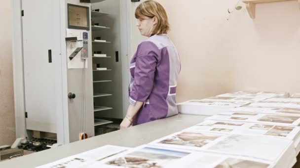 Mujer que trabaja en la industria del polígrafo - máquina de carpetas en la imprenta
 - Metraje, vídeo