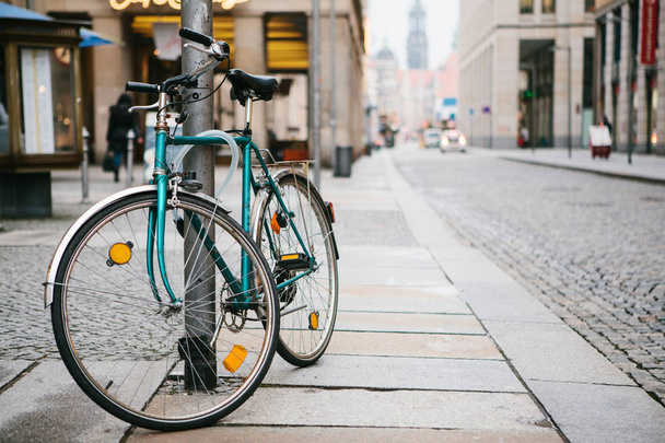 The bike parked next to the pole and secure with locking device on the streets of European cities. Conceptual image of a healthy lifestyle and environmental form of transport. - 写真・画像