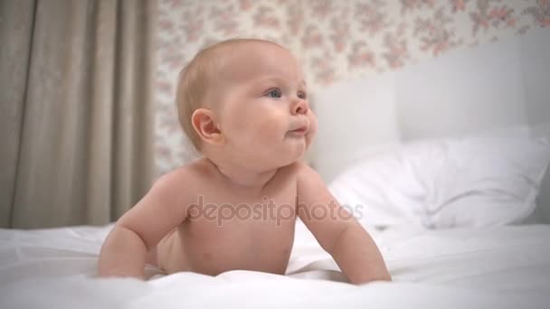 Bella bambina poggia sulle mani sul letto bianco al rallentatore
 - Filmati, video