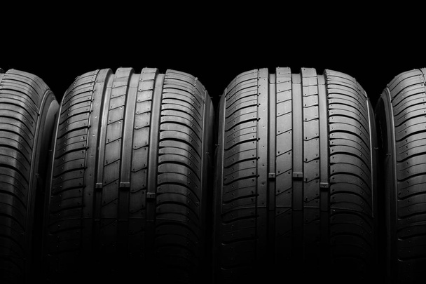 neumáticos de coche sobre fondo negro - Foto, Imagen