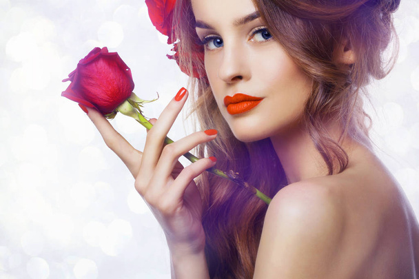 Beautiful  fashion Woman with red lips and nails.Roses on hand - Photo, Image