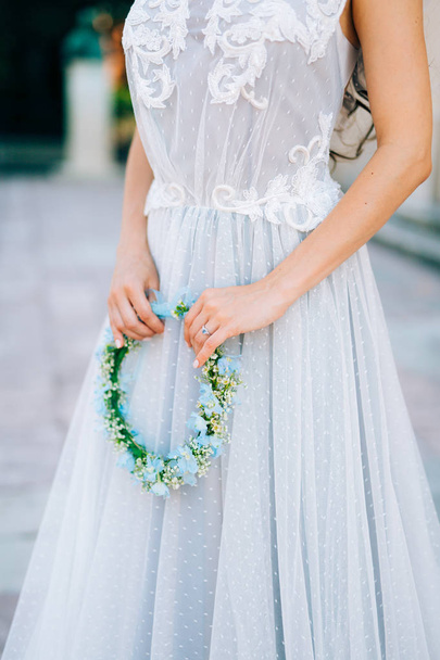 Wieniec na głowę niebieskie i białe kwiaty w brides ręka i - Zdjęcie, obraz