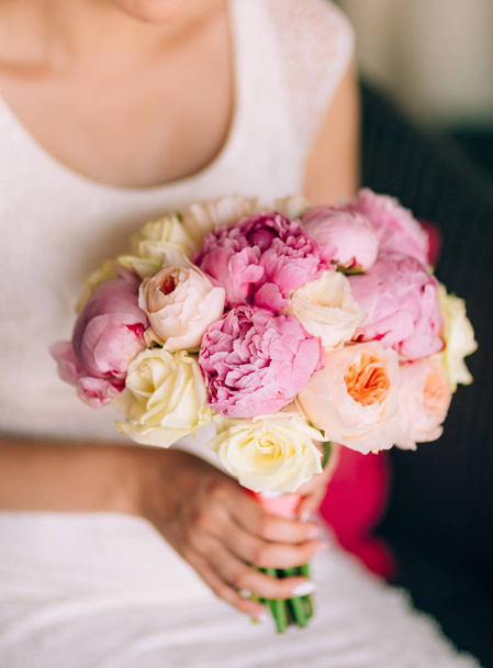 Rosas de boda y peonías en las manos de la novia. Boda en
 - Foto, Imagen