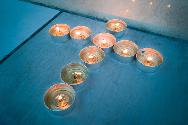 Luci da tè a candela nella formazione crocifissa cristiana
 - Foto, immagini