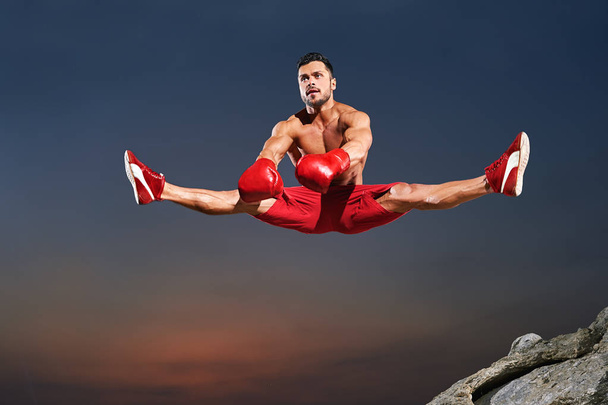 Atleta di sesso maschile che fa spaccature in aria mentre salta
 - Foto, immagini