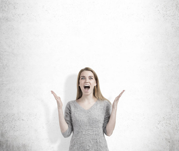 Screaming woman near concrete wall - Фото, зображення
