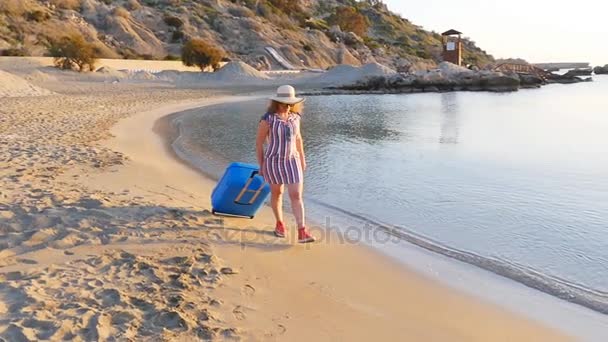 Привлекательная молодая женщина с чемоданом на пляже
. - Кадры, видео