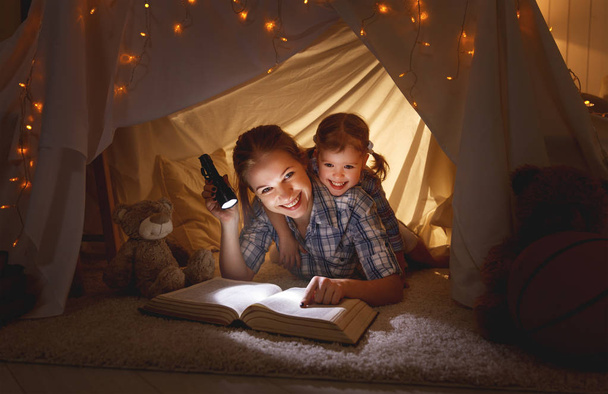 mother and child daughter with a book and a flashlight before go - Photo, Image