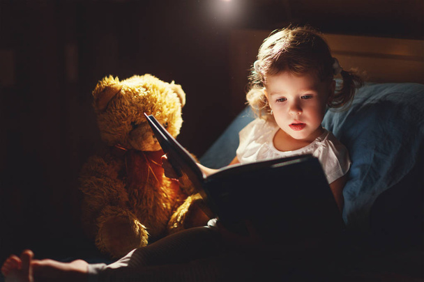 dziecko dziewczynka czytania książki w łóżku  - Zdjęcie, obraz