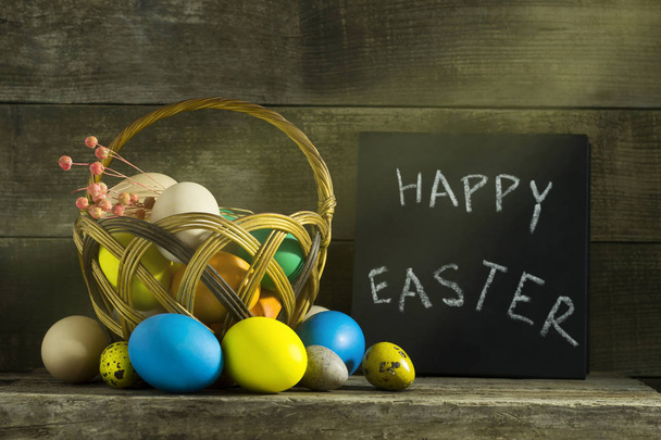 Bodegón de Pascua con huevos coloridos sobre un fondo de madera viejo
. - Foto, Imagen
