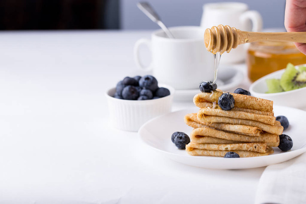 Breakfast with thin pancakes (crepes), blueberries and coffee - Photo, Image