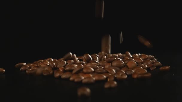 Granos de café - Caída. Una macro toma de 96 FpS de granos de café cayendo sobre la superficie negra. Un tiro genérico hermoso para cualquier tema relacionado con el café o fondos de título
 - Imágenes, Vídeo