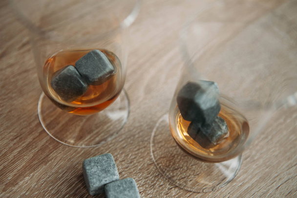 Stones for cooling whiskey and glases tulup on light wooden background - Valokuva, kuva