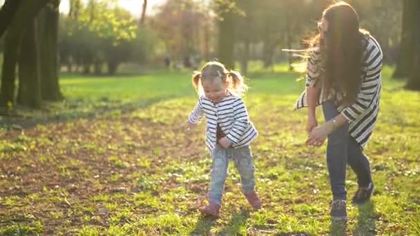 Αστείο, μικρό κορίτσι είναι τρέχει μακριά από της μητέρας παίζει σε εξωτερικούς χώρους με το πάρκο. Ενεργό θηλυκό παιδί τη διασκέδαση κατά τη διάρκεια της ηλιόλουστη ημέρα άνοιξη. - Πλάνα, βίντεο