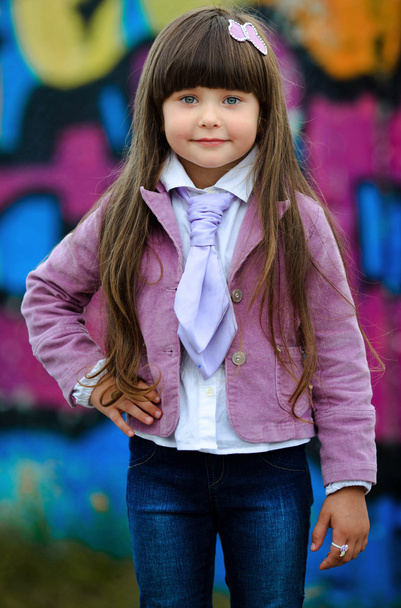Portrait of little girl outdoors in a pink jacket - Foto, imagen