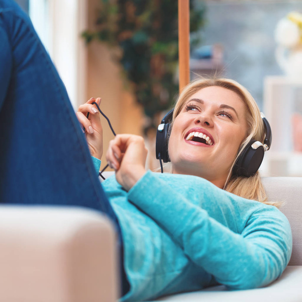 Young woman listening to music on headphones - Photo, image