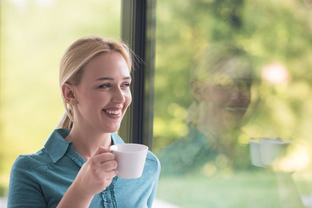 young woman drinking morning coffee by the window - Фото, зображення