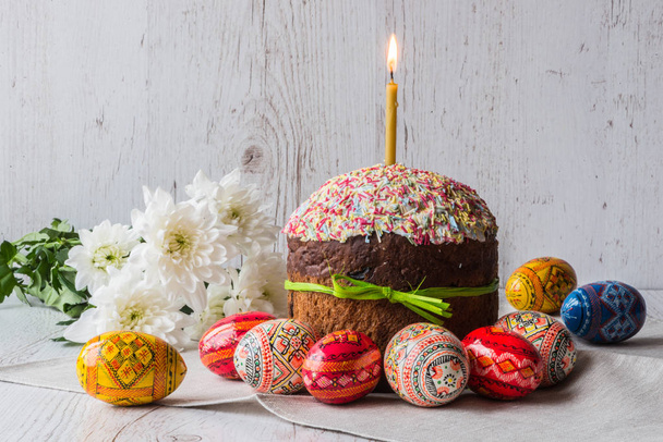 gâteau de Pâques kulich avec des œufs et des fleurs de printemps sur fond de bois clair
 - Photo, image