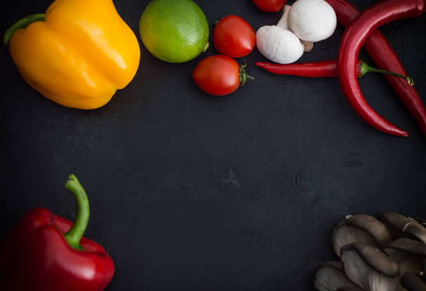 Different vegetables on a black stone background. Top view - Foto, Imagen
