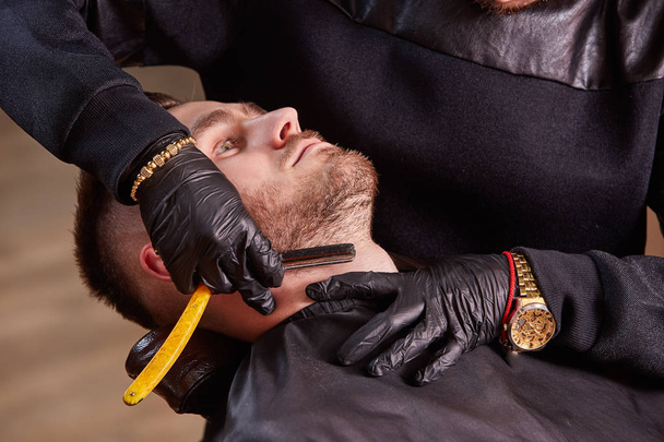 Master makes beards correction with shaver in barbershop salon. Close up photo. - Fotografie, Obrázek
