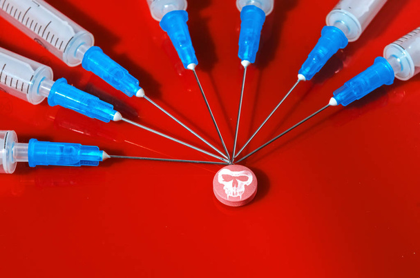 Syringe. Pills. Syringes with tablets on a red background. Injectors with medical preparations - Foto, Bild