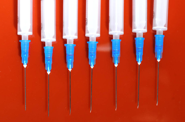 Syringe. Pills. Syringes with tablets on a red background. Injectors with medical preparations - Zdjęcie, obraz