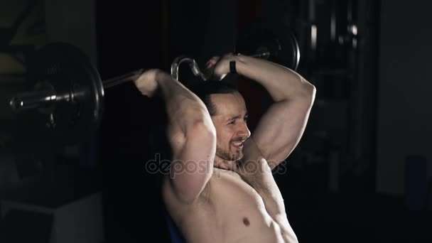 Man lifting barbell behind his head - Materiał filmowy, wideo