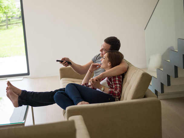Televizyon izlerken koltukta genç Çift - Fotoğraf, Görsel