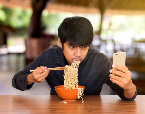 Člověk jíst při hledání a používání smartphonu - Fotografie, Obrázek