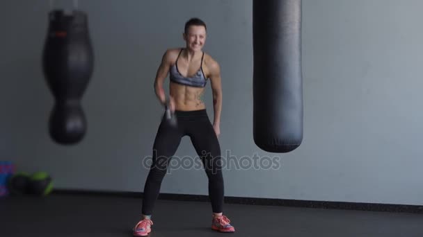 Urheilu nainen tekee vatsalihasliikkeitä painoilla lisätä lihasmassaa käsissä
. - Materiaali, video