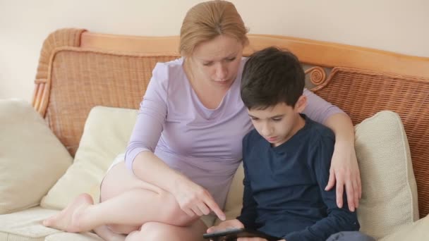Mom and her son teenager speak well, look at the tablet touch the touch screen - Кадри, відео
