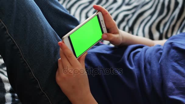 タッチ スクリーン デバイスを持ち、少年のクローズ アップ手をスマート フォンを使用します。クロマキー、緑色の画面 - 映像、動画
