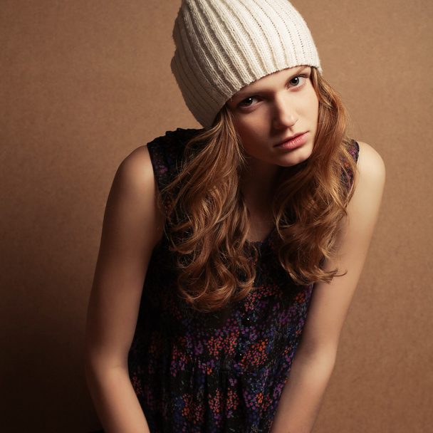 Fashionable model with curly red hair and beige hat posing over - Photo, image