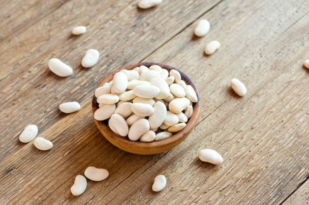 Organic Raw White Beans in wooden bowl close up - healthy ingredient for diet vegan vegetarian protein food meal cuisine, ready for cooking - Photo, image