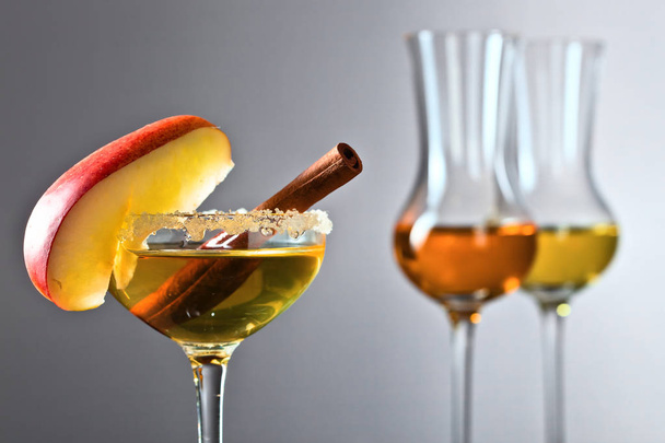 Glas van zoete alcoholische drank met appel en kaneel  - Foto, afbeelding