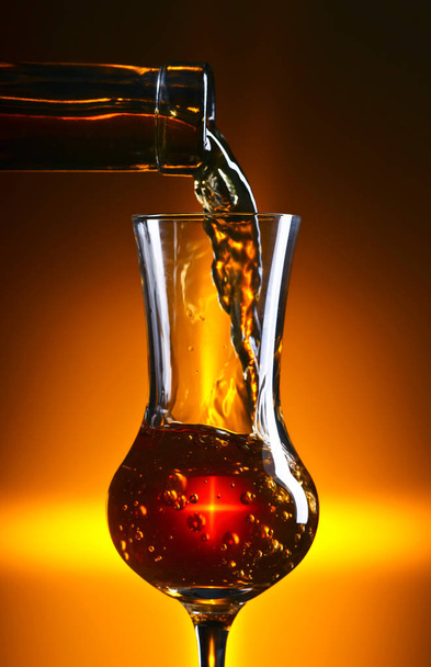 Einschenken alkoholischer Getränke in ein Weinglas  - Foto, Bild
