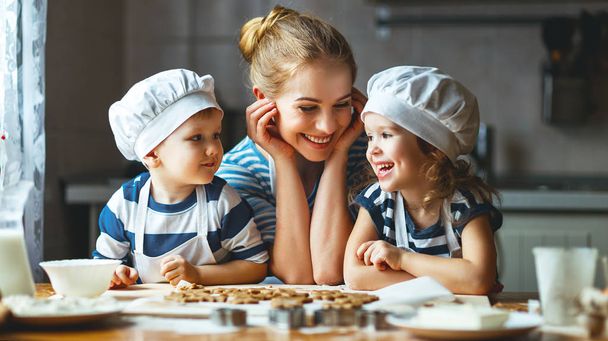happy family in kitchen. mother and children preparing dough, ba - Фото, изображение