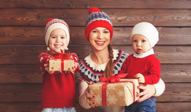 happy family mother and children with christmas gift at wooden b - Photo, image