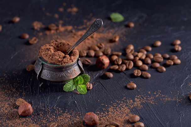 Hazelnut, coffee beans and cocoa powder in dark background. - Photo, Image