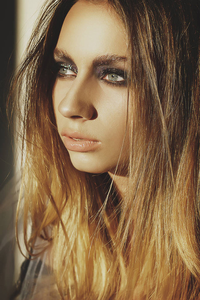 Beauty portrait of a young blond girl with smoky eyes makeup. Ar - Photo, Image