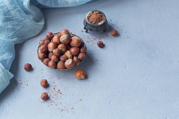 Hazelnut, coffee beans and cocoa powder in light blue background - Photo, Image