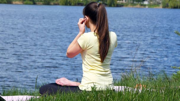 Dziewczyna siedzi na trawie i relaksu, medytacji - Zdjęcie, obraz