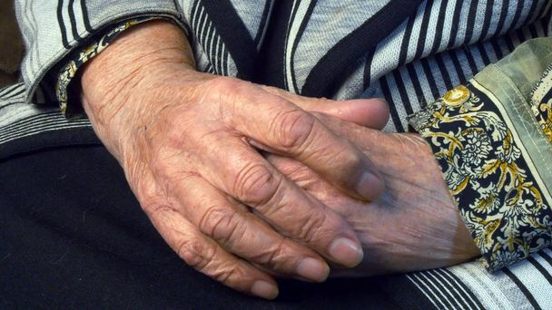 年配の女性は、痛みを伴う手をマッサージします。 - 写真・画像